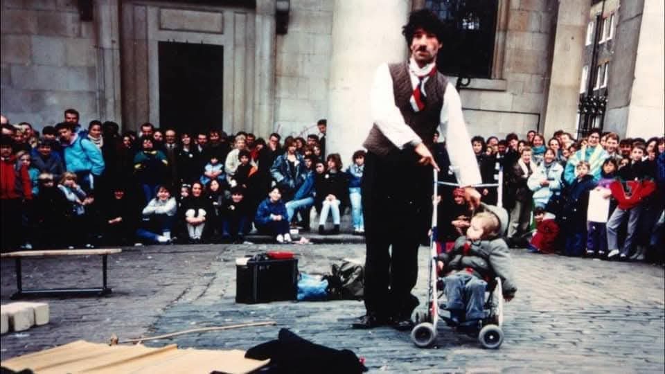 A large Covent Garden crowd watching Charlie perform with a child