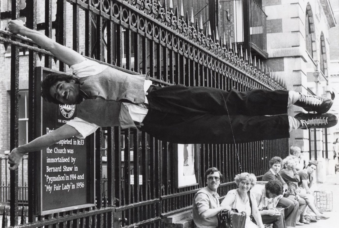 Charlie hanging horizontally from the railings at Covent Garden